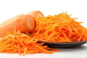2 whole carrots and shredded carrots in black plate on display